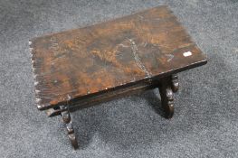 An antique carved oak cracket stool dated 1706 with carved coat of arms