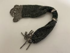 A Late 19th Century metal bead work miser's purse, with twin metal rings and tassel ends,