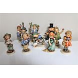 Nine Hummel figures together with a Goebel figure.