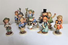 Nine Hummel figures together with a Goebel figure.