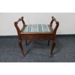 An Edwardian oak storage piano stool