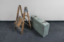 A pair of folding wooden stool steps and a luggage case