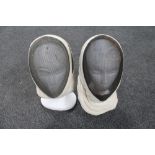 Two fencing masks on polystyrene heads