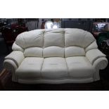 A cream leather three seater settee