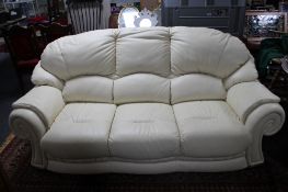 A cream leather three seater settee