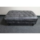 A black leather oversized footstool