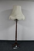 A mahogany standard lamp with shade on tripod stand