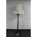 A mahogany standard lamp with shade on tripod stand