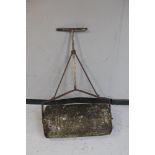 An antique concrete garden roller with cast iron handle
