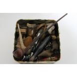 A box of antique and later pipes, carved treen pieces, figure of a man, Black Forest style bear,