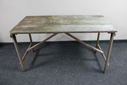 A mid 20th century folding wooden trestle table