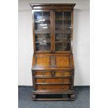 An early 20th century carved oak bureau bookcase with plaque '1879-1929, Presented to Mr. William I.
