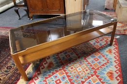 A mid 20th century teak smoked glass topped coffee table
