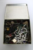 A tin of costume jewellery, buttons,