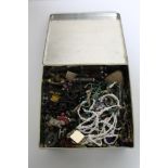 A tin of costume jewellery, buttons,