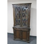 A carved oak leaded door corner cabinet