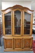 An American style dome topped triple door display cabinet