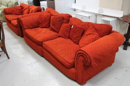 A contemporary four seater and two seater settees upholstered in burnt rust coloured fabric,