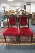 A pair of late Victorian mahogany dining chairs upholstered in a red dralon