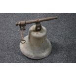 An antique cast metal church bell with bracket