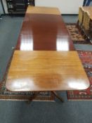 A mid 20th century mahogany triple pedestal dining room table with three leaves,