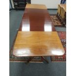 A mid 20th century mahogany triple pedestal dining room table with three leaves,