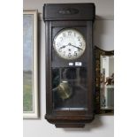 An Edwardian oak cased wall clock with silvered dial