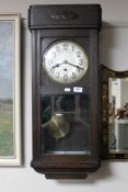 An Edwardian oak cased wall clock with silvered dial