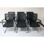 A set of six black Sipis office armchairs on tubular metal legs