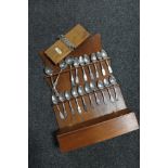 An Edwardian wooden spoon rack fitted with a glove box containing pewter spoons, tie press.