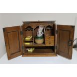 An Edwardian oak smoker's cabinet, with Art Nouveau inset metal panels to the double doors,