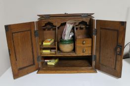 An Edwardian oak smoker's cabinet, with Art Nouveau inset metal panels to the double doors,