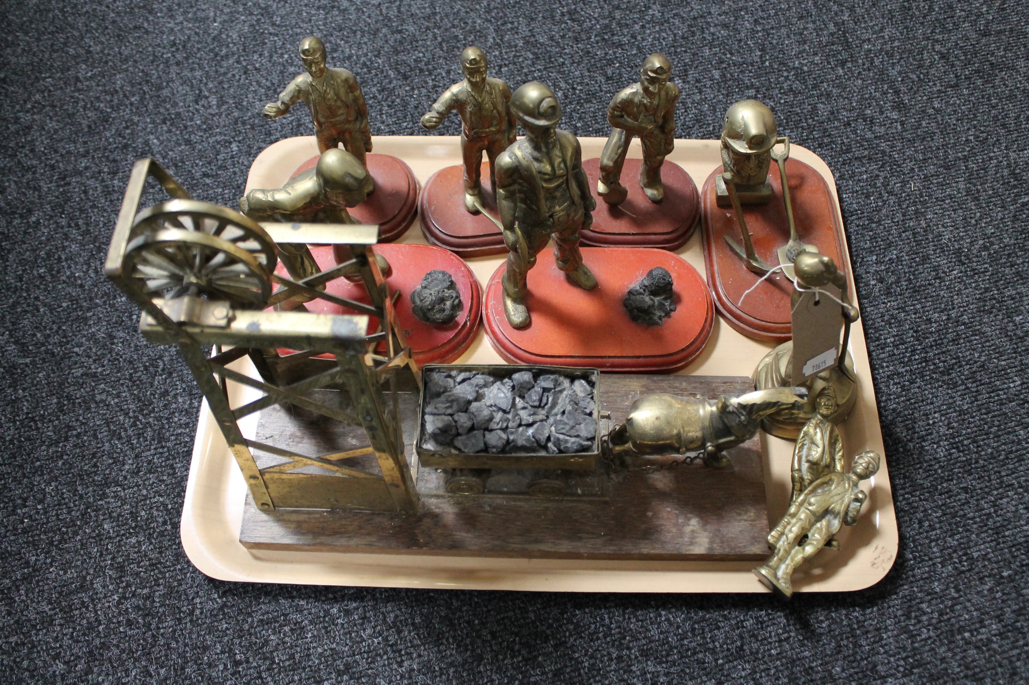 A tray of brass mining figures