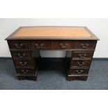 A mahogany Regency style pedestal writing desk with nine drawers and tooled leather top