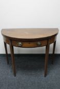A Victorian inlaid mahogany demi lune tea table fitted with a drawer