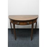 A Victorian inlaid mahogany demi lune tea table fitted with a drawer