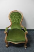 A Victorian carved oak framed gentleman's armchair in green dralon