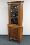 An Edwardian oak astragal glazed corner cabinet