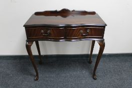 A mahogany serpentine fronted Regency style hall table fitted with two drawers