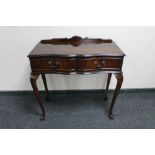 A mahogany serpentine fronted Regency style hall table fitted with two drawers