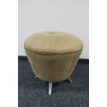 A circular circular footstool on metal legs