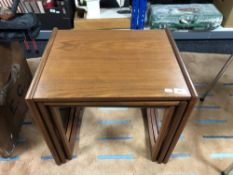 A nest of three mid century teak tables