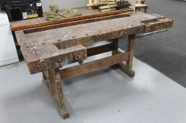 An early 20th century wooden work bench with two wooden vices