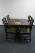 An early 20th century oak pull out dining table with four rail backed chairs on carved legs