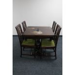 An early 20th century oak pull out dining table with four rail backed chairs on carved legs