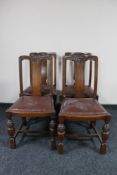 A set of four carved Edwardian oak dining chairs