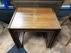 A nest of three mid century teak tables