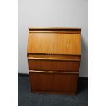 A mid century teak writing bureau