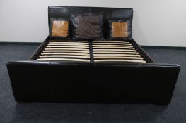 A 6' brown leather bed frame together with three large brown leather scatter cushions
