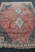An Iranian Kashgai rug of zoomorphic design on red ground,